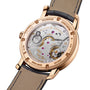 The back view of the Vacheron Constantin Traditionnelle Manual-winding showcases its mechanical movement, intricate engravings, a brown leather strap, and an 18K pink gold case.