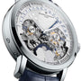 Close-up of a Vacheron Constantin Traditionnelle Perpetual Calendar Retrograde Date Openface watch, featuring a transparent dial that reveals intricate gears, multiple date and day indicators, and a blue strap.