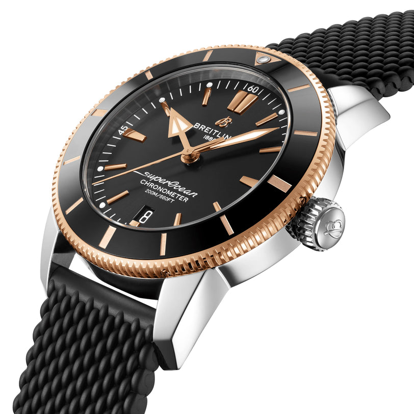 A close-up of the Breitling Superocean Heritage B20 Automatic 44 shows its black dial with gold accents, luminescent hands, and black textured strap, displaying the time at 10:08.