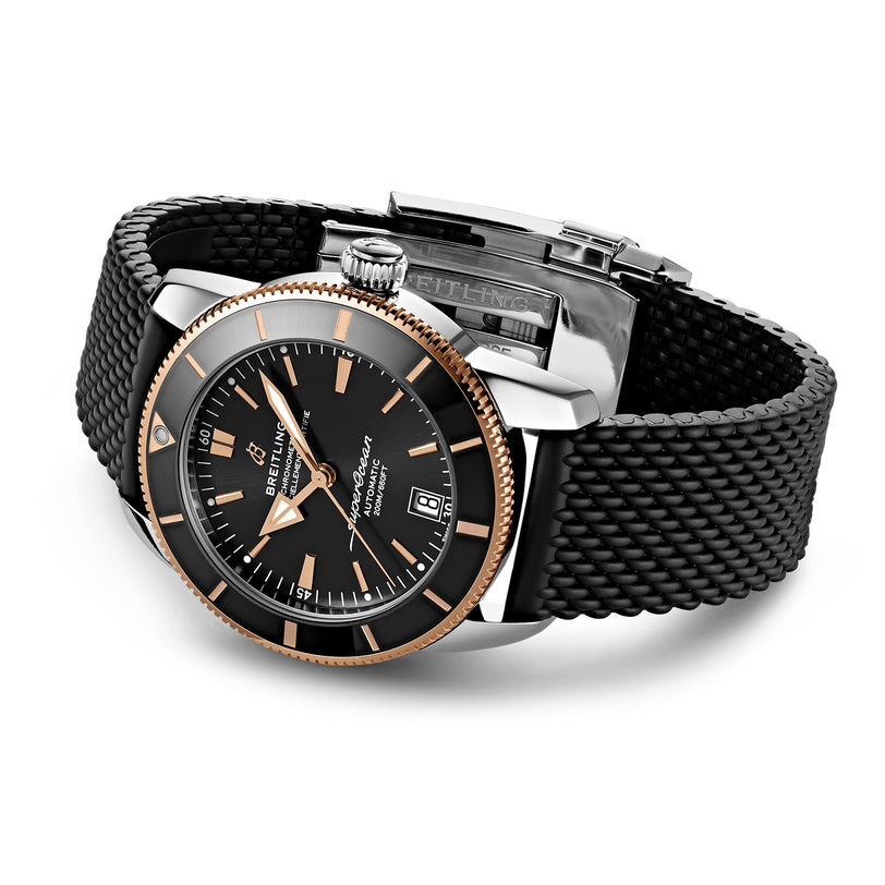 Mens Breitling Superocean Heritage B20 Automatic 42 with black woven strap, black and gold bezel, black dial, gold-tone markers, date at 3 o’clock, and water-resistant design.
