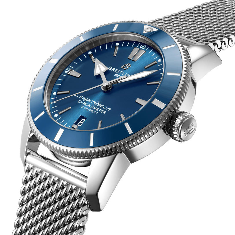 A close-up of a Breitling Superocean Heritage B20 Automatic 44 watch featuring a blue dial, date window, silver hour markers, stainless steel case, and stainless steel mesh bracelet.