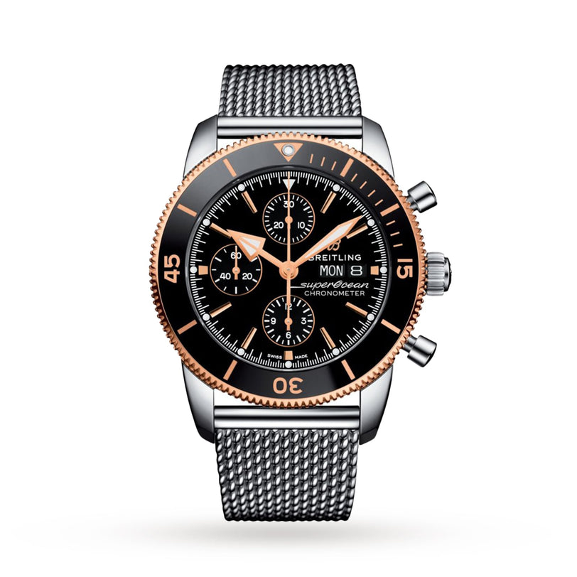 The Breitling Superocean Heritage B20 Automatic 44 features a black and gold bezel, black dial with three subdials, 44mm stainless steel case, and a water-resistant silver mesh metal band.
