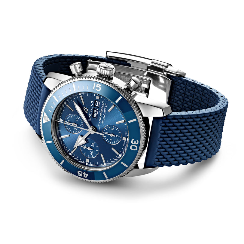 A Breitling Superocean Heritage Chronograph 44 wristwatch with a blue textured strap, silver bezel, and multiple subdials, powered by the Breitling 13 calibre, shown on a white background.