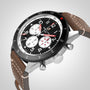 The Breitling Super AVI B04 Chronograph GMT 46 Mosquito features a black dial with three white subdials, red and white hands, a stitched brown leather strap, and a stainless steel case inspired by aviation history.