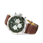 The Breitling Super AVI B04 Chronograph GMT 46 Curtiss Warhawk features a green dial with three white subdials, silver case, and brown leather strap with white stitching, shown at an angle and inspired by aviation heritage.