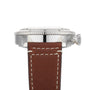 Close-up side view of the Breitling Super AVI B04 Chronograph GMT 46 Curtiss Warhawk, showcasing its stainless steel case, ridged bezel, crown, and brown leather strap with white stitching—echoing aviation heritage.