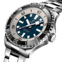 A close-up angled view of the Breitling Superocean Automatic 44, a stainless steel dive watch with blue and cream dial, bold markers, rotating bezel, metal bracelet, and automatic movement.
