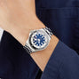Dressed in a navy long-sleeve shirt, a person wears the Breitling Superocean Automatic 44 dive watch, featuring a blue dial, silver bezel, and metal bracelet.