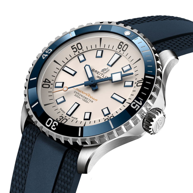 A close-up of the Breitling Superocean Automatic 42 dive watch featuring a blue bezel, white dial, black hour markers, and a blue textured strap, powered by the Breitling Calibre 17 movement.
