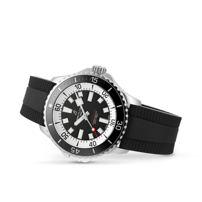 The Breitling Superocean Automatic 46, a stainless steel dive watch with a black and white dial, black bezel, and black rubber strap, is displayed at an angle on a white background.
