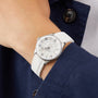 A person wearing a Breitling Superocean Automatic 36 dive watch in silver and white with Super-LumiNova and a white strap, paired with a navy blue jacket and white shirt.