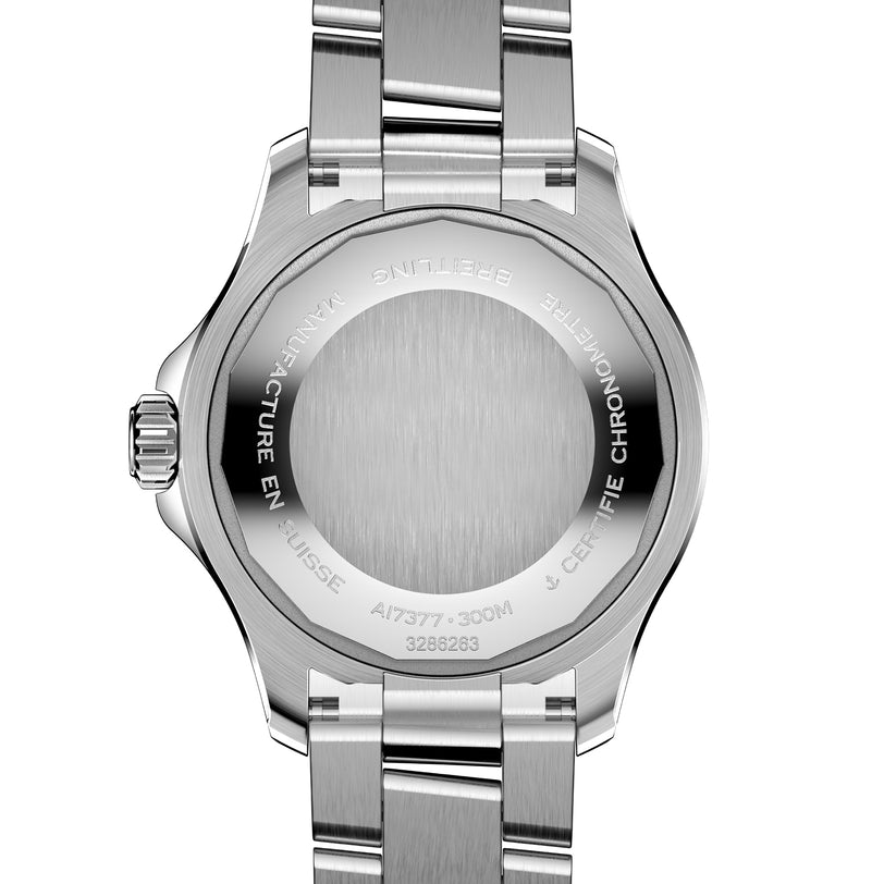 The image shows the back of a Breitling Superocean Automatic 36 diving watch, featuring engraved text around the edge and a brushed stainless steel center that highlights its distinct design.