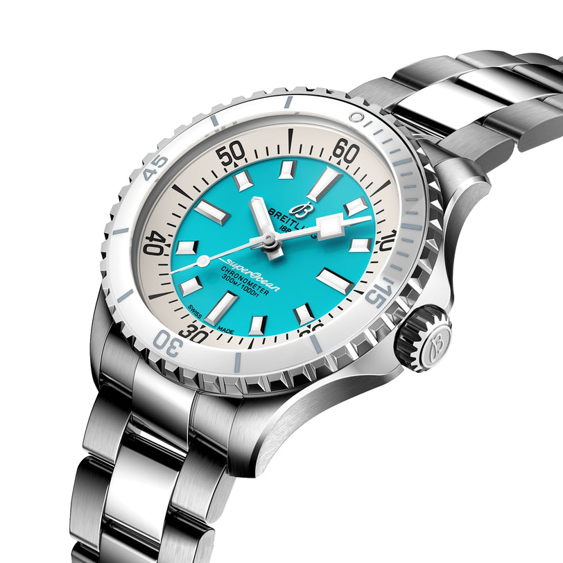 The Breitling Superocean Automatic 36 is a stainless steel dive watch featuring a turquoise dial, bold white hour markers, and a ceramic bezel, shown at an angle on its metal bracelet.