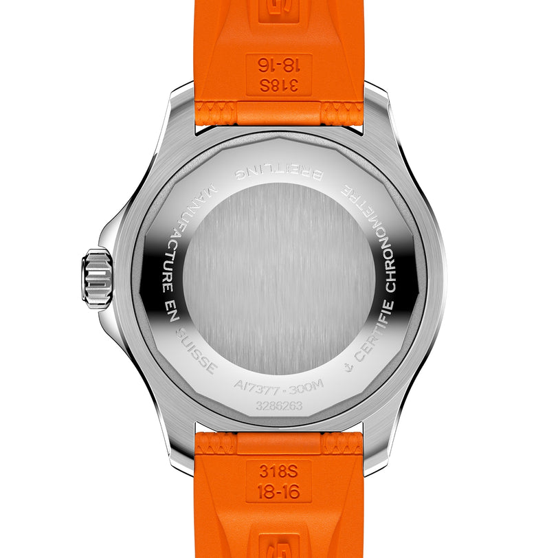The caseback of the Breitling Superocean Automatic 36 dive watch showcases engraved text and a brushed stainless steel center, complemented by a vibrant tangerine rubber strap.