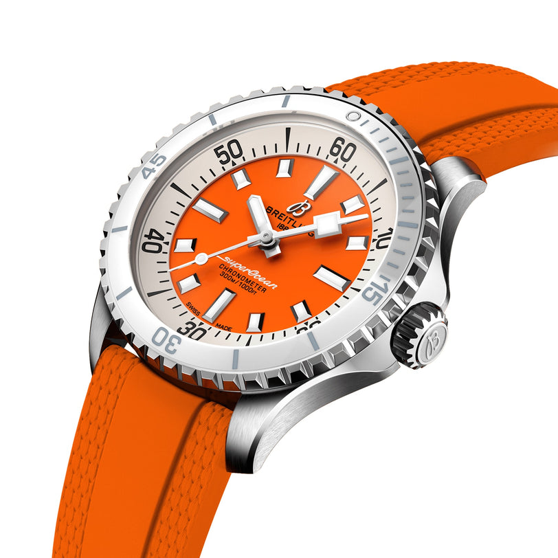 The Breitling Superocean Automatic 36 is a stainless steel dive watch with an orange dial, tangerine rubber strap, black and white hour markers, and rotating bezel, displayed at an angle on a white background.