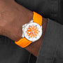 A person wears a Breitling Superocean Automatic 36 dive watch with an orange dial and tangerine rubber strap on their left wrist over a dark gray shirt.