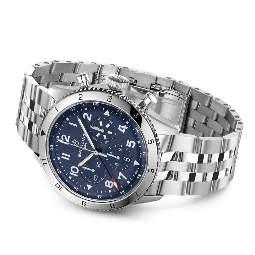 The Breitling Super AVI B04 Chronograph GMT 46 Tribute To Vought F4U features a stainless steel case, blue dial with silver markers, three subdials, metal link band, minute-marked bezel, right crown, and is powered by the B04 Manufacture calibre.