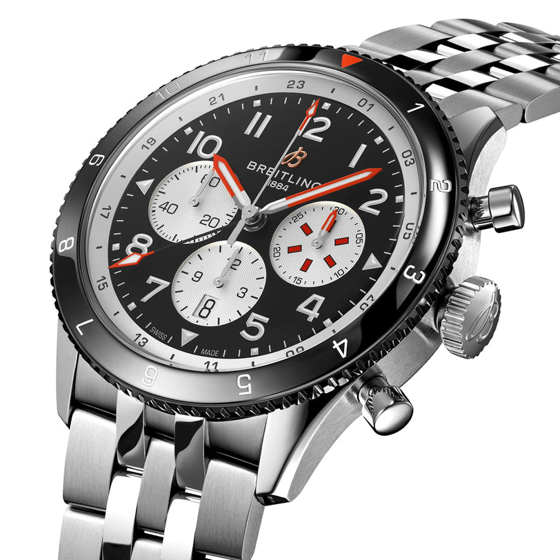 A stainless steel Breitling Super AVI B04 Chronograph GMT 46 Mosquito wristwatch with a black bezel, black dial, three subdials, red accents, and a metal bracelet.