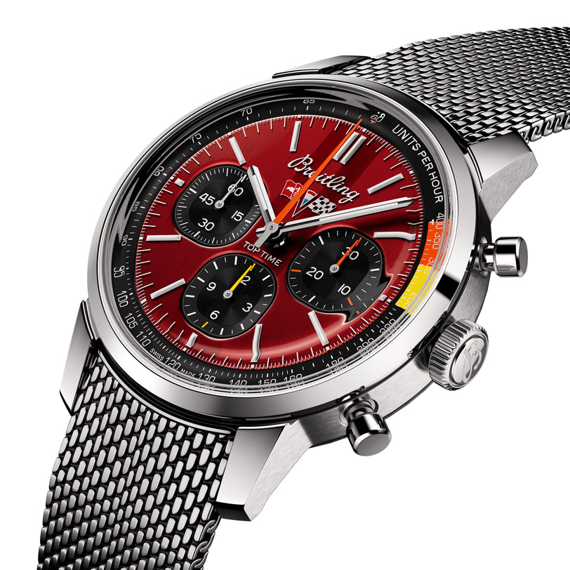 The Breitling Top Time B01 Chevrolet Corvette is a stainless steel wristwatch with a red racing chronograph dial, three black subdials, and a mesh metal band, displayed at an angle against a white background.