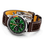 The Breitling Top Time B01 Ford Mustang is a luxury wristwatch with a racing green dial, three subdials, a stainless steel case, and a brown perforated leather strap with white stitching.