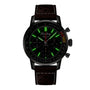 The Breitling Top Time B01 Ford Mustang is a black chronograph watch with a brown leather strap, green-illuminated markers, multiple dials, and features the precise Breitling Manufacture Calibre 01 movement on a dark background.