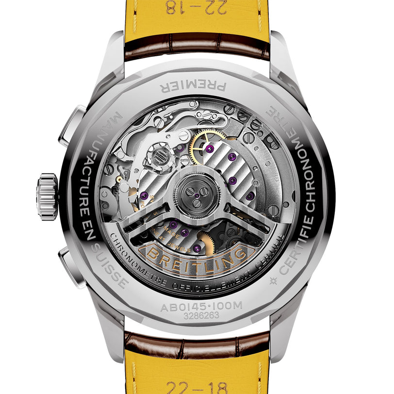 Close-up of the back of a Breitling Premier B01 Chronograph 42, showing its exposed automatic movement, intricate gears, chronograph features, and engraved details on the metal case with a yellow leather strap.