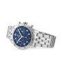 A Breitling Classic AVI Chronograph 42 Tribute To Vought F4U wristwatch with a blue dial, silver indices, three subdials, and a stainless steel bracelet is displayed on a white background.
