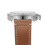 Close-up side view of the Breitling Classic AVI Chronograph 42 P-51 Mustang with a polished metal case, grooved bezel, and brown leather strap with white stitching, highlighting the precise chronograph movement.