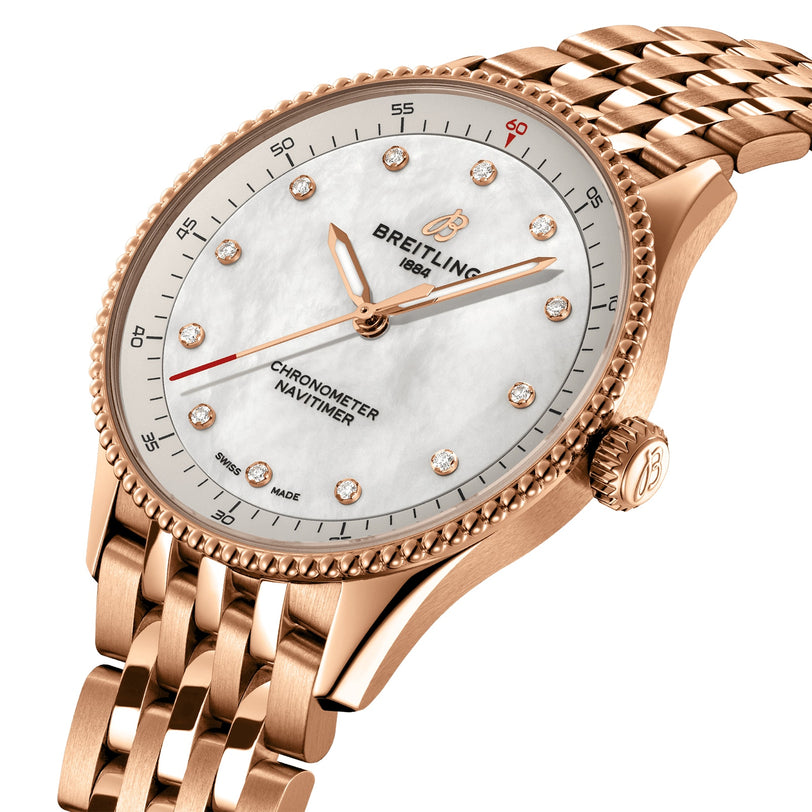 The Breitling Navitimer 32 is an 18K red gold chronometer watch with a white mother-of-pearl dial, diamond hour markers, and a matching rose gold link bracelet.