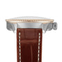 Side view of the Breitling Navitimer Automatic 36, featuring a brown leather strap, metal case, beaded bezel, and crown on the right side.