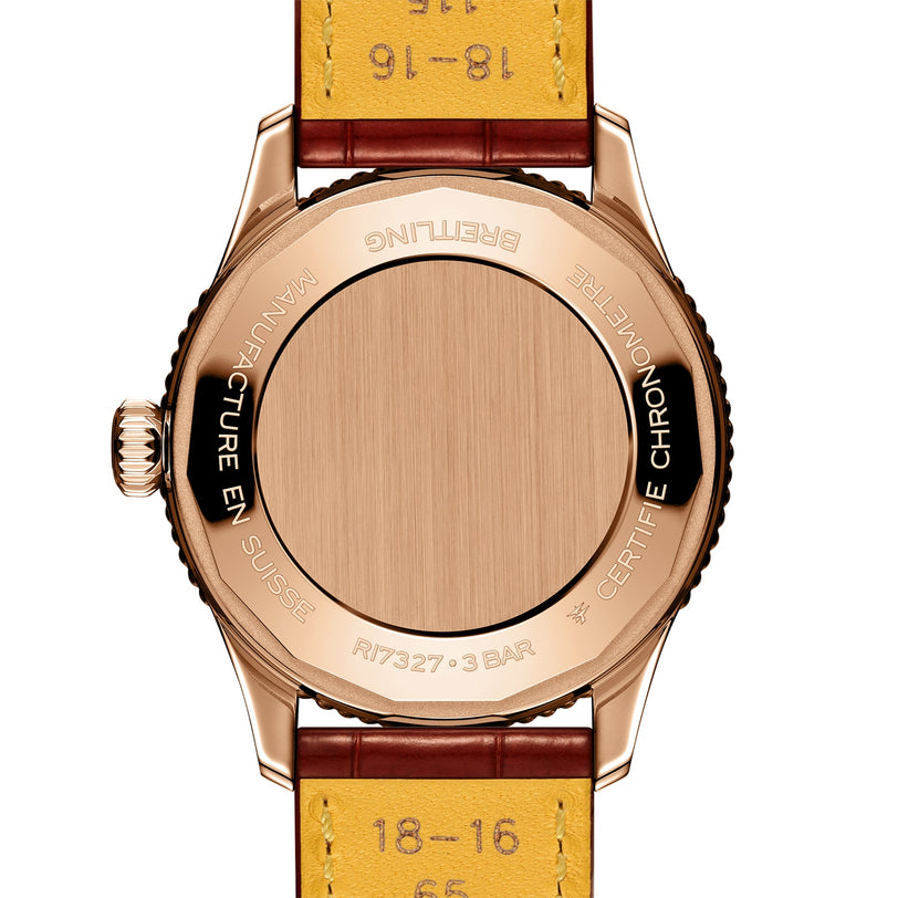 The image shows the back of a Breitling Navitimer Automatic 36 wristwatch with a rose gold case, brown and yellow leather straps, and engraved text around the case back.