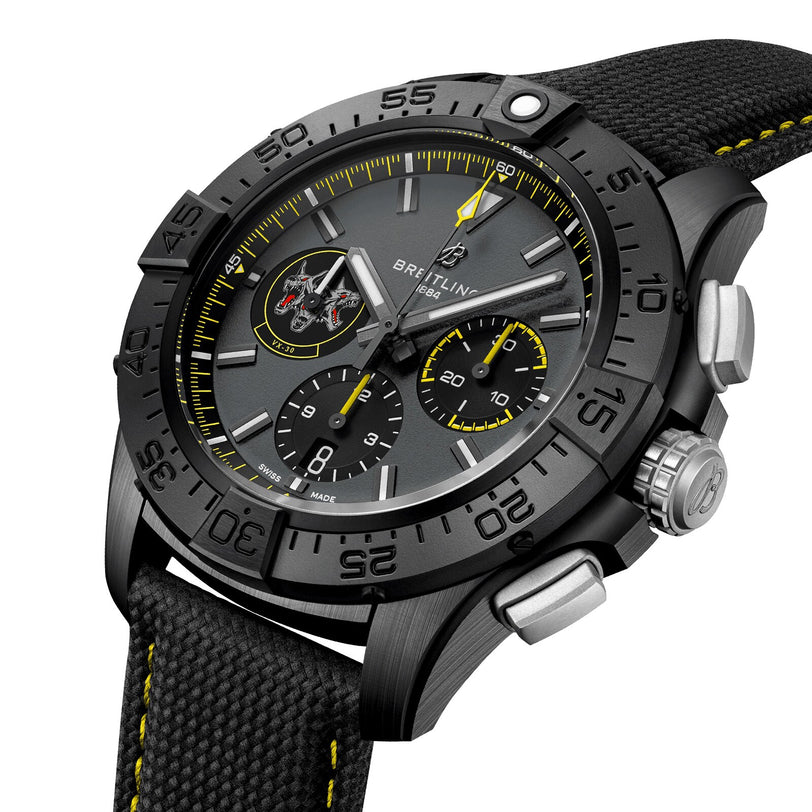 Close-up of the Breitling Avenger B01 Chronograph 44 Night Mission Bloodhounds, featuring a black case, fabric strap, yellow accents, three subdials, U.S. Navy logo, and powered by the Manufacture Caliber 01.