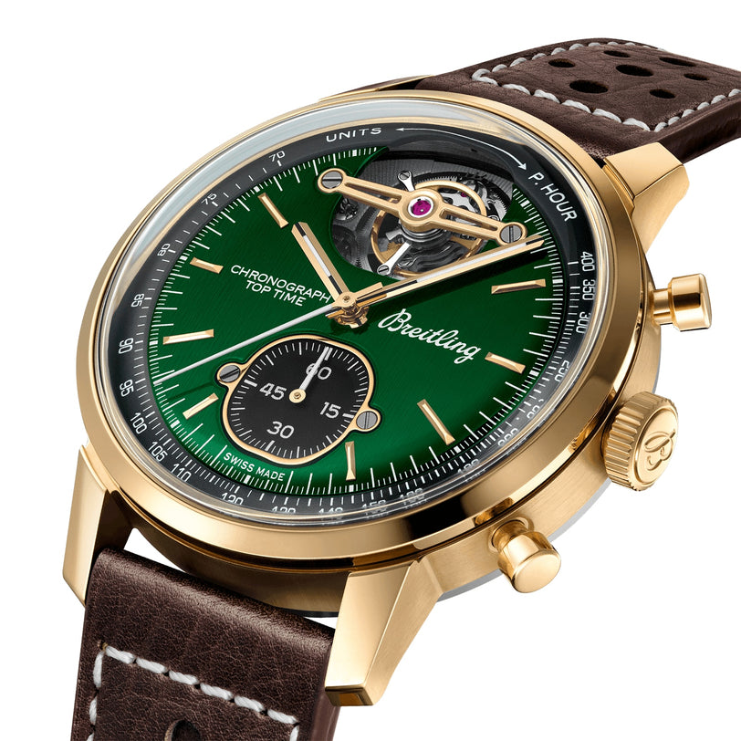 The Breitling Top Time B21 Ford Mustang is a gold chronograph wristwatch with a green dial, exposed tourbillon, brown leather strap, and visible stopwatch subdial—capturing the spirit of vintage racing and classic Mustang dashboards.