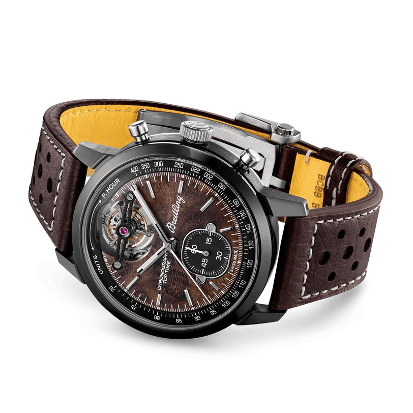 The Breitling Top Time B21 Chevrolet Corvette is a luxury watch featuring a brown leather strap, black bezel, visible tourbillon, racing chronograph features, and a wood-textured dial inspired by classic sports cars.