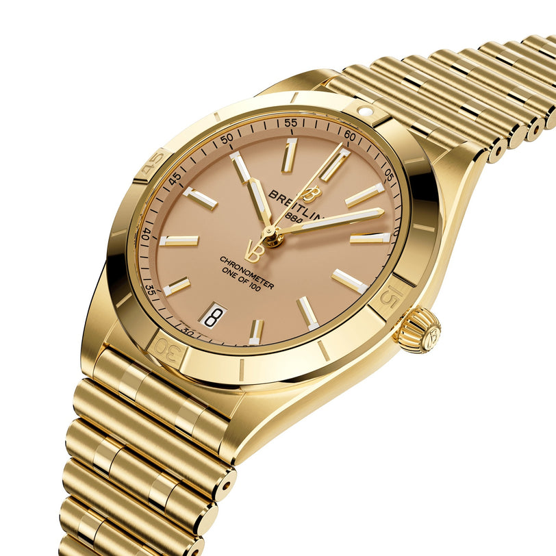 A Breitling Chronomat Automatic 36 Victoria Beckham wristwatch in 18K yellow gold featuring a gold dial, stick markers, date window at 6 o’clock, and an 18K gold bracelet.