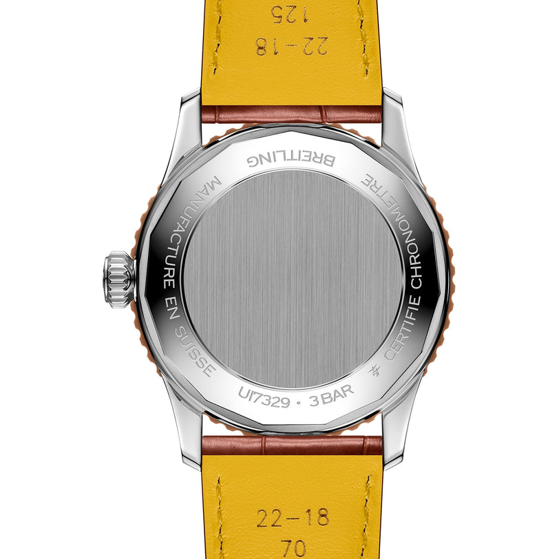 A close-up of the back of the Breitling Navitimer Automatic 41 wristwatch, featuring a yellow leather strap, stainless steel case, and aviation-inspired engravings.