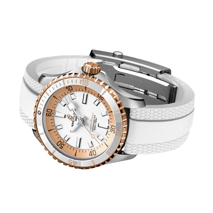 The Breitling Superocean Automatic 36 dive watch features a silver and gold case, gold bezel, white face, and white textured rubber strap, displayed on a white background to highlight its automatic movement.