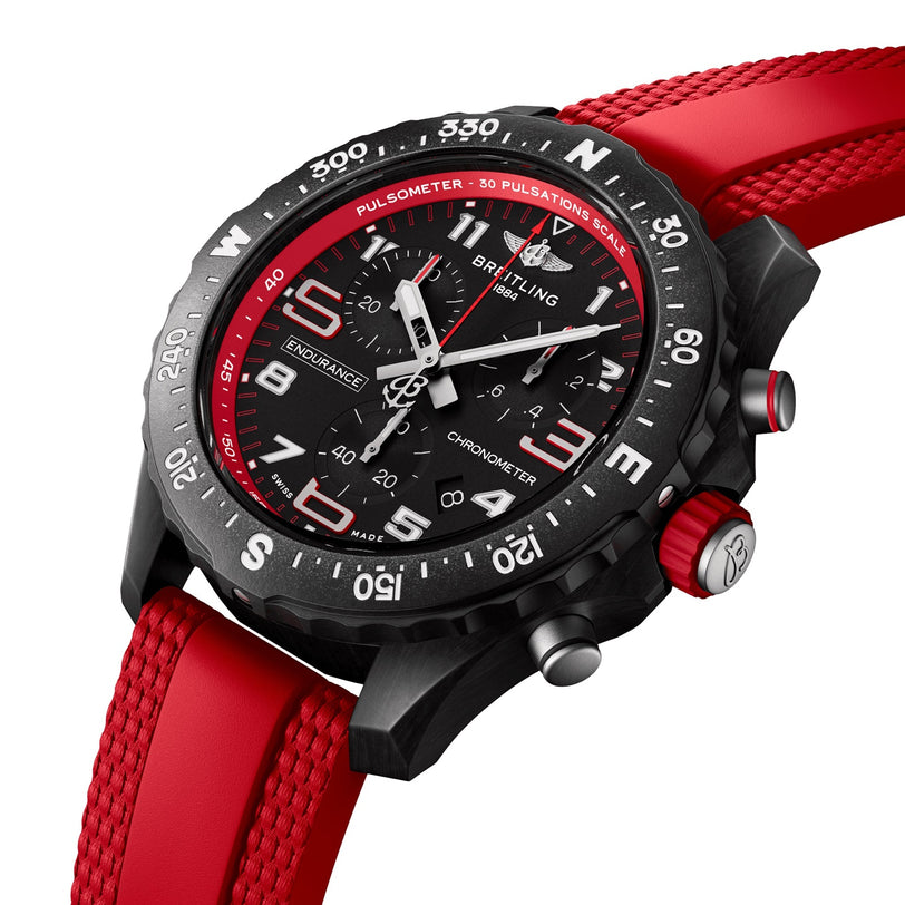 The Breitling Endurance Pro 38 is a black chronograph athleisure watch with an ultra-light Breitlight case, red bezel and strap, plus white dial numbers—ideal for sporty lifestyles. Shown on a white background.