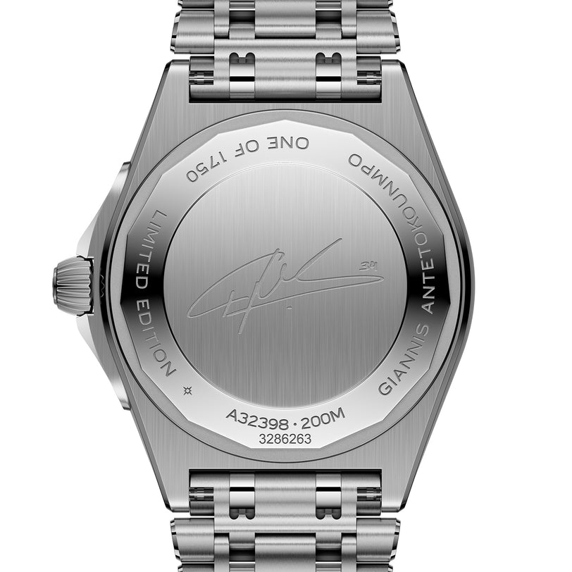 The back of a Breitling Chronomat Automatic GMT 40 Giannis Antetokounmpo wristwatch showcases engraved text, a signature, and serial numbers on its stainless steel case with the watch band attached.