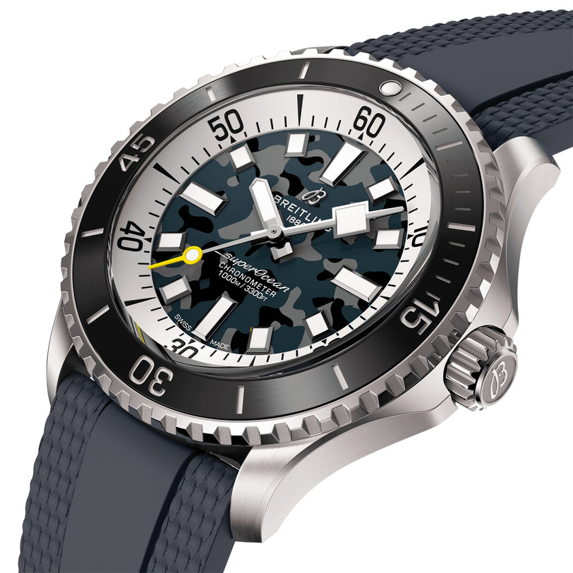 A close-up of the Breitling Superocean Automatic 46 Super Diver, featuring a blue camouflage dial, yellow seconds hand, rotating bezel, titanium case, and a textured dark strap.