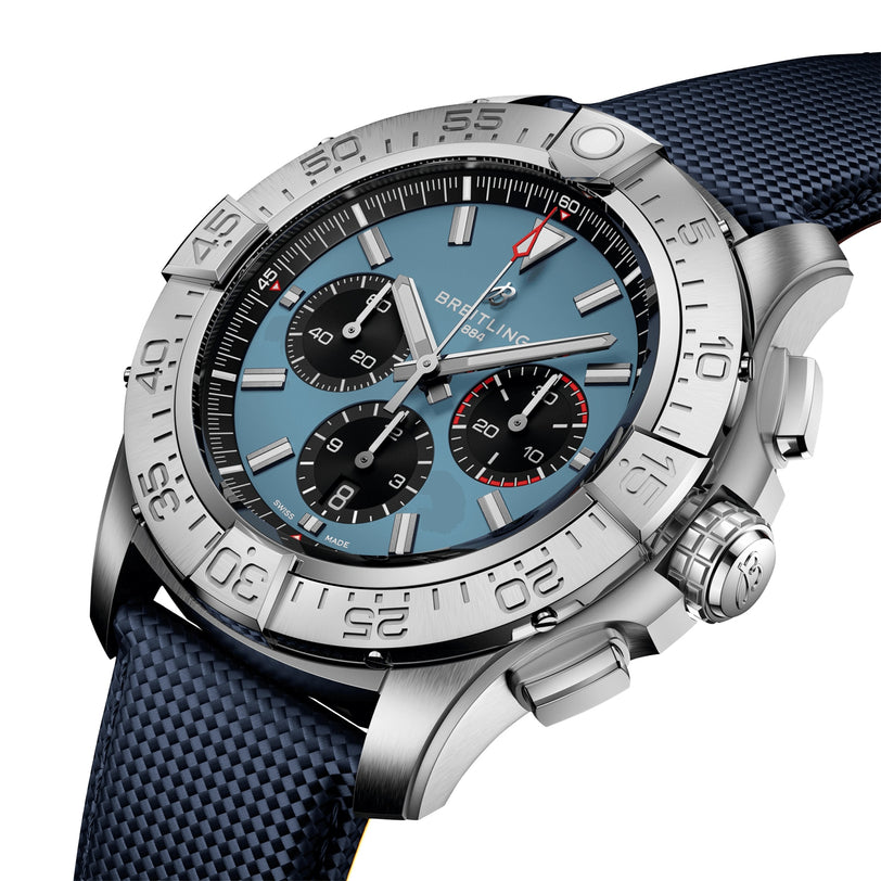 The Breitling Super Avenger B01 Chronograph 46 features a stainless steel case, blue dial with three subdials, date display, and an aviation-style textured blue strap.