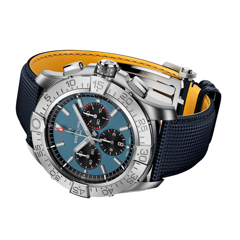 The Breitling Super Avenger B01 Chronograph 46 features a stainless steel case, blue dial with three subdials, rotating bezel, and a textured blue strap with yellow underside, expressing bold aviation style.