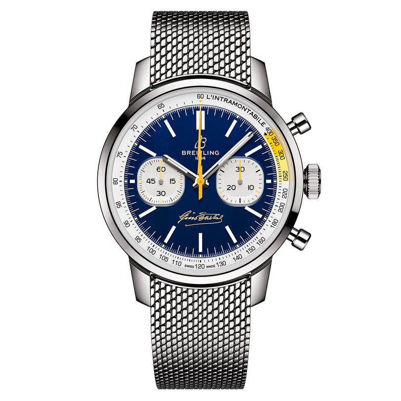 The Breitling Top Time B01 Gino Bartali is a stainless steel chronograph featuring a blue dial, two white subdials, yellow accents, silver mesh band, and iconic Breitling branding on the face.