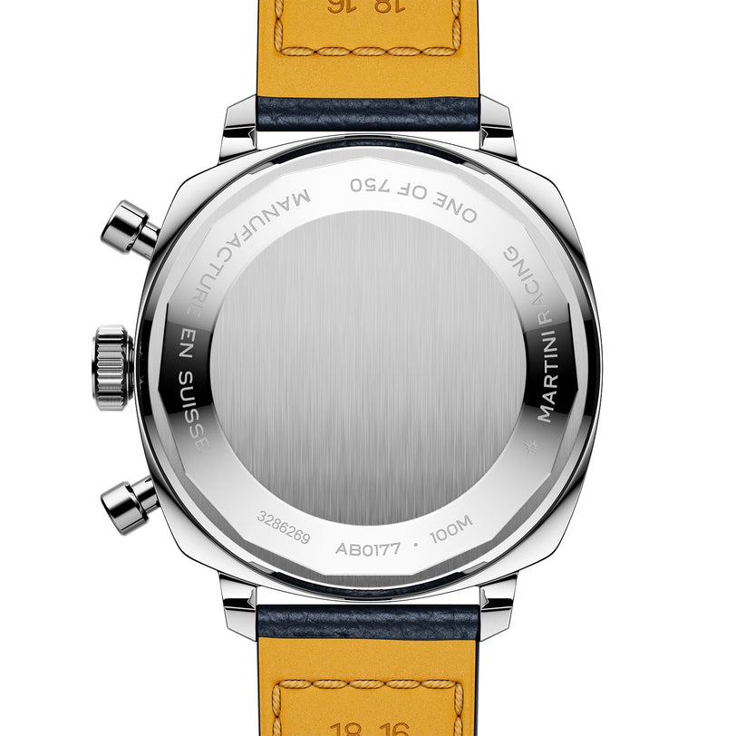 A close-up of the back of the Breitling Top Time B01 Racing wristwatch shows a brushed metal case, two buttons, engraved text, and a two-tone leather strap—a true homage to racing-inspired chronographs.