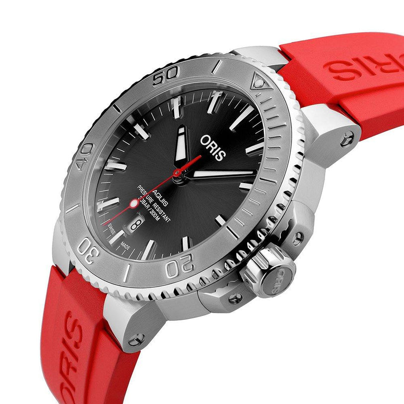 The Oris Aquis Date Relief is a stainless steel divers watch featuring a black dial, date display, rotating bezel, and a striking red rubber strap.