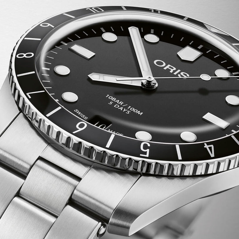 Close-up of an Oris Divers Sixty‑Five 12H Calibre 400 dive watch in stainless steel with a black dial and bezel, showing the time at 10:09.