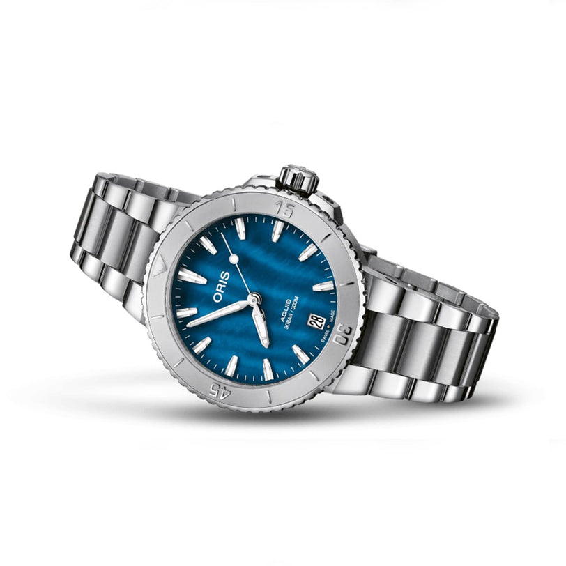 Oris Aquis Date silver wristwatch with a blue dial, silver hour markers, and a metal link bracelet shown against a white background.