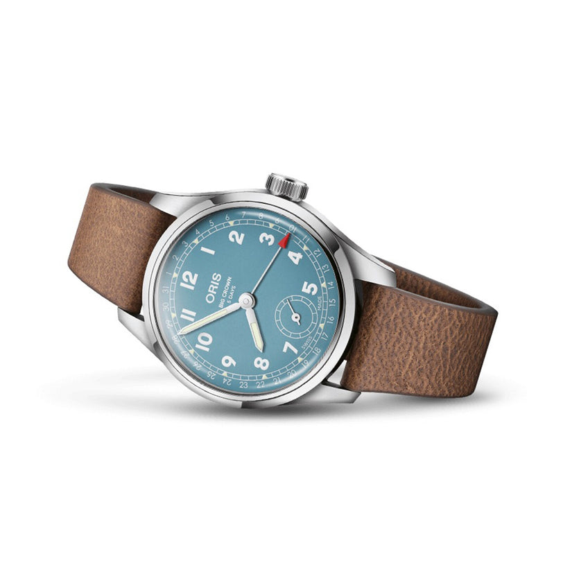 The Oris Big Crown Pointer Date Calibre 473, featuring a blue dial with white numerals, small seconds subdial, silver case, and brown leather strap, is displayed on a white background.