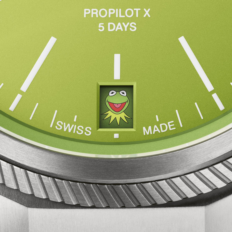 Close-up of the Oris ProPilot X Kermit Edition shows its green watch face, 5 Days label, Swiss Made text, and a small Kermit the Frog image above 6 o’clock.