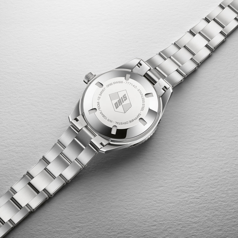 The Oris Divers Sixty‑Five Cotton Candy wristwatch, shown from the back, features a silver metal band and displays engraved branding and details.